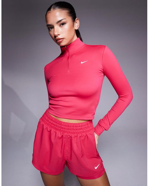 Nike - one training - top manches longues ajusté à col zippé Nike en coloris Pink