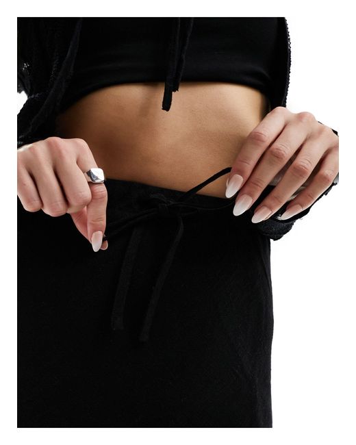 Jupe mi-longue coupée en biais en aspect lin avec lien noué à la taille ASOS en coloris Black