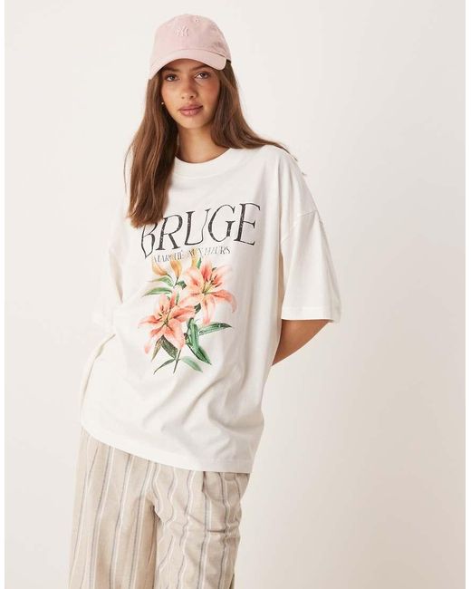 Camiseta Extragrande Con Estampado Gráfico De Flor Y Texto "Bruge" De -Blanco ASOS de color Natural