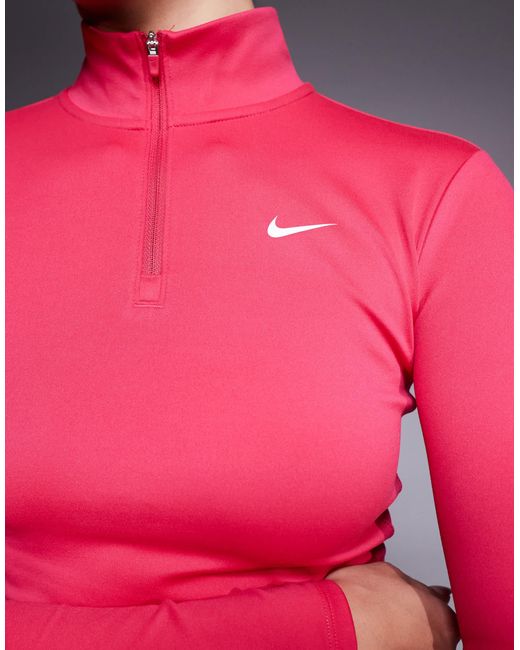 Nike - one training - top manches longues ajusté à col zippé Nike en coloris Pink