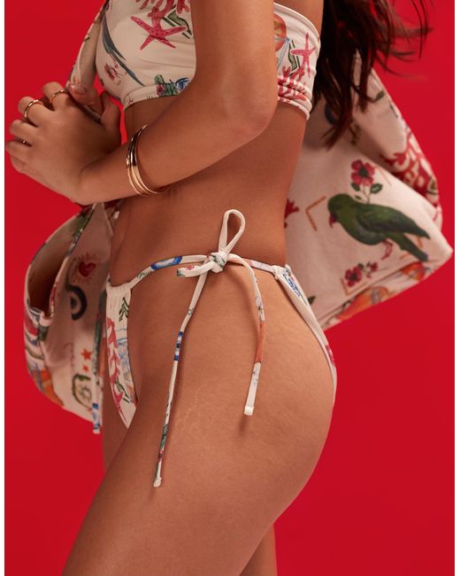 Slip bikini con stampa stile cartolina e allacciatura laterale di ASOS in Red