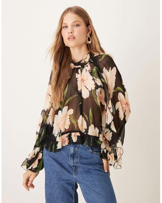 Blouse transparente à col rond et manches longues - base foncée fleurie Mango en coloris Blue