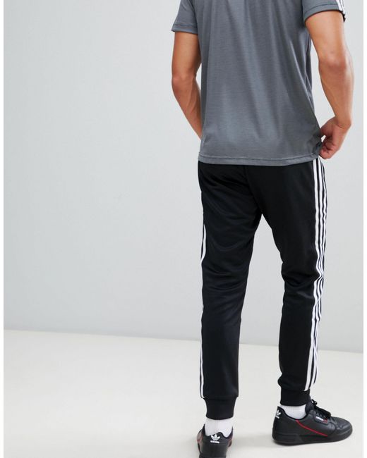 adidas originals superstar 3 stripe joggers in black
