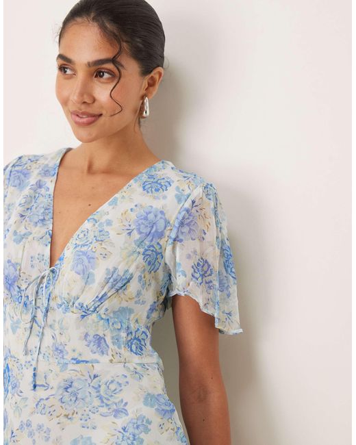 Robe longueur mollet à imprimé fleuri et manches courtes avec col v à détail noué - pastel Mango en coloris Natural