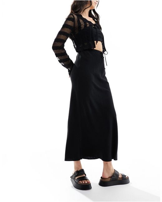 Jupe mi-longue coupée en biais en aspect lin avec lien noué à la taille ASOS en coloris Black