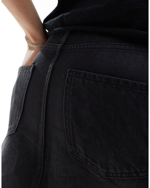 Mini-jupe découpée en jean - délavé Collusion en coloris Black