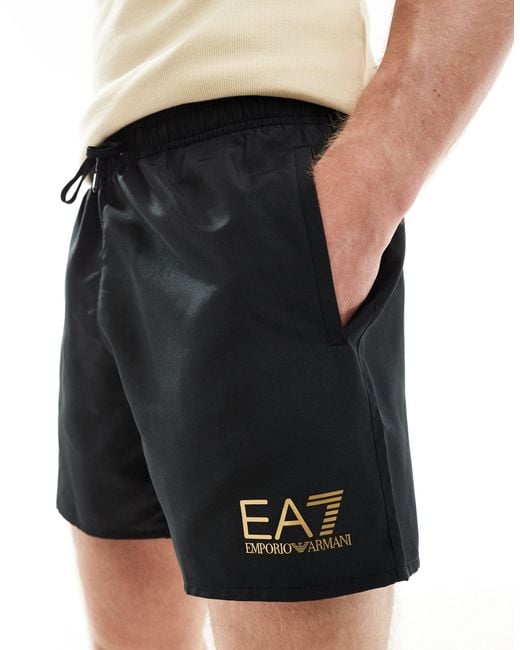 EA7 Black Armani Gold Logo Swim Shorts for men