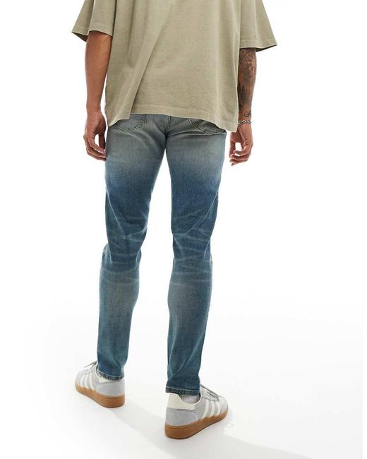 Vaqueros De Corte Pitillo Con Lavado Azul Medio Y Acabado Tintado De ASOS de hombre de color Blue