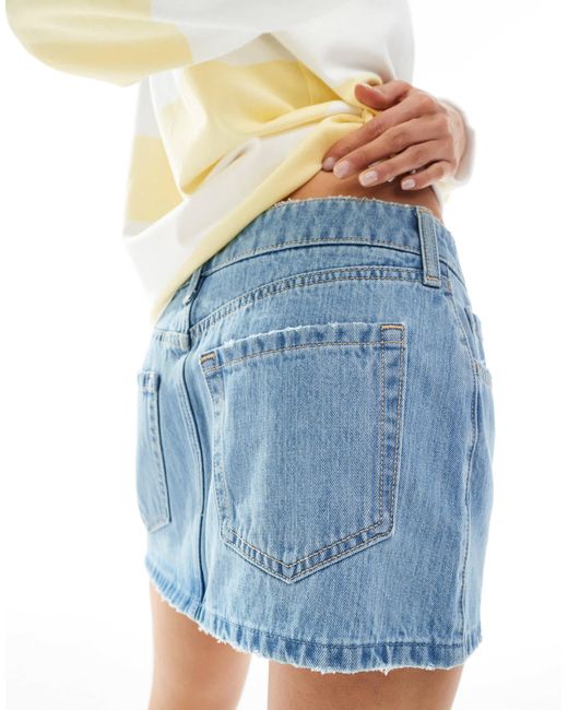 Mini-jupe taille basse en jean à ourlet effrangé - moyen Hollister en coloris White