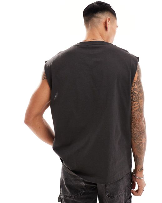 Camiseta negro lavado holgada sin mangas con estampado gráfico Cotton On de hombre de color Black