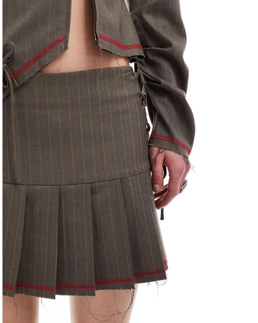 Mini-jupe plissée d'ensemble avec laçage et ourlet brut Collusion en coloris Natural
