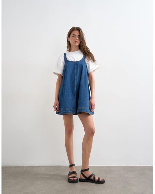 denim pinny dress ASOS DESIGN denim pinny dress in midwash blue