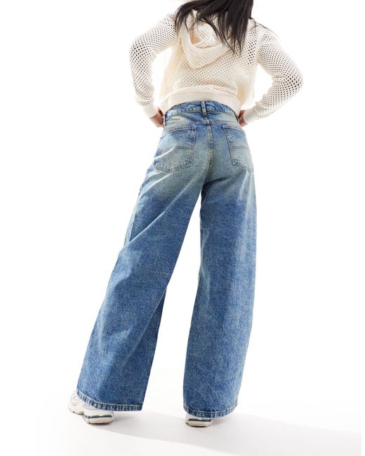 X013 - jeans con fondo ampio a vita medio alta lavaggio medio di Collusion in Blue