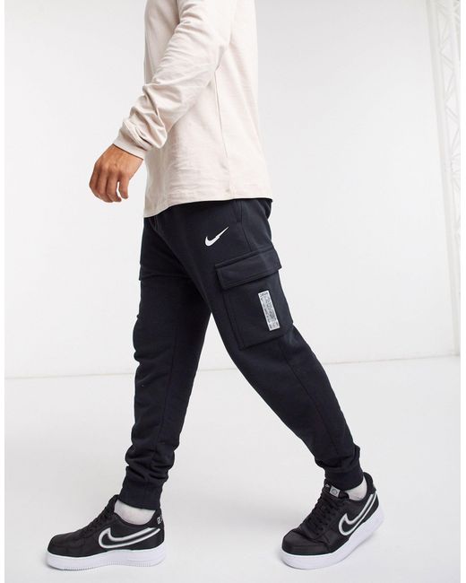 Swoosh On Tour Pack - Jogger cargo avec chevilles resserrées Nike pour homme en coloris Black