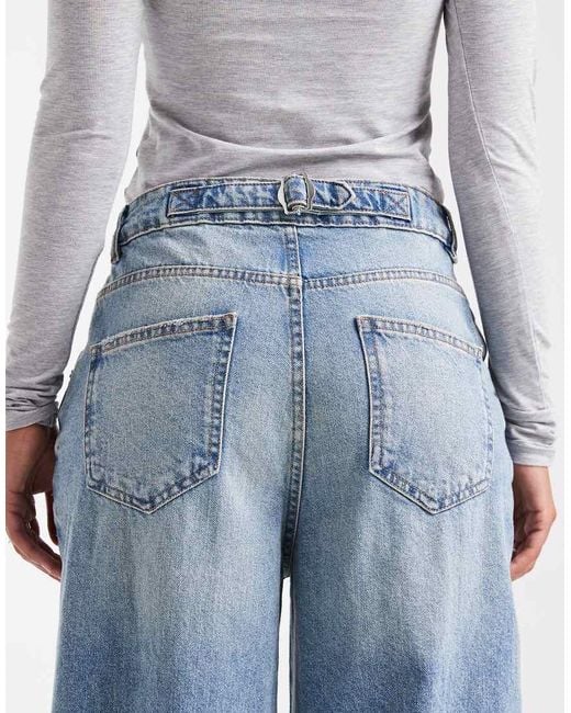 Vaqueros De Pernera Ancha Y Talle Alto Con Lavado Envejecido Tenue Y Detalle De Tira Ajustable De -Azul ASOS de color Blue