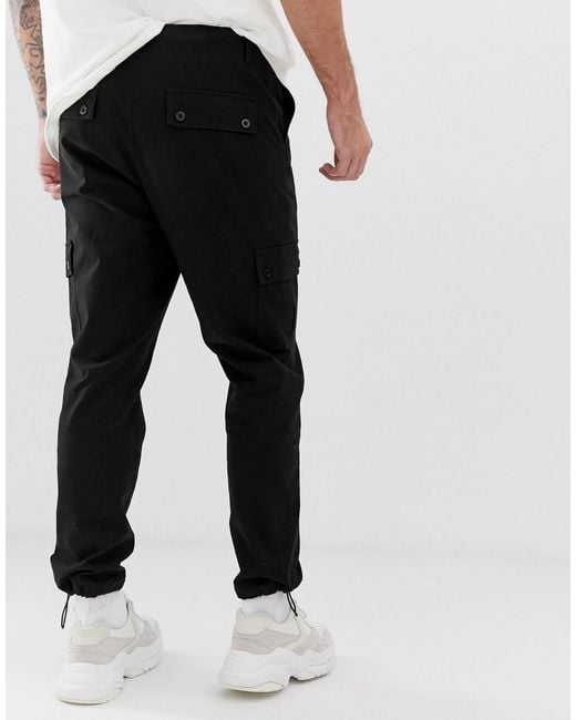 Pantalon Cargo Fusele Avec Fermetures A Bouton Stoppeur Coton Asos Pour Homme En Coloris Noir Lyst