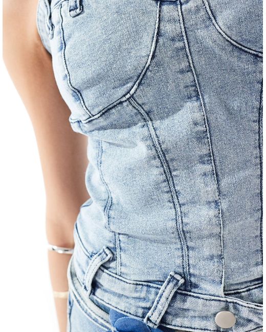 Simmi - top a corsetto di jeans strutturato con scollo a cuore lavaggio chiaro con collarino con fiore di SIMMI in Blue