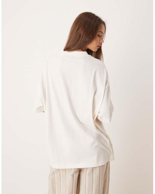 Camiseta Extragrande Con Estampado Gráfico De Flor Y Texto "Bruge" De -Blanco ASOS de color Natural