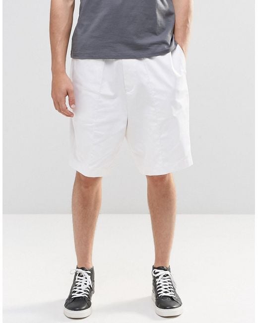 White tailored shorts These tailored swim shorts are printed in a mazed-geometry for an illusional texture when sitting by the pool. Pull-tight waist tabs give a secure, retro fit. BUY.