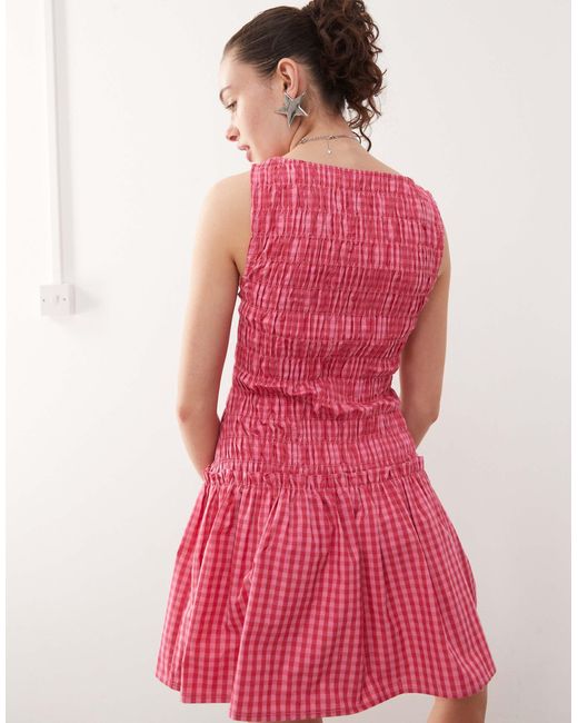 Robe froncée courte à taille basse et carreaux Collusion en coloris Pink