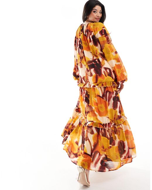Asos design curve - vestito grembiule lungo accollato con stampa a fiori sfocata e volant di ASOS in Orange