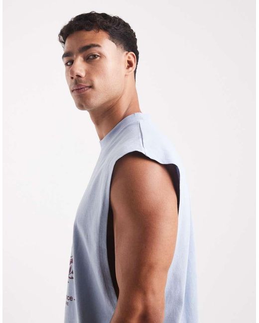 Camiseta Azul Claro Extragrande Sin Mangas Con Sisas Caídas Y Estampado Gráfico Urbano De ASOS de hombre de color Blue