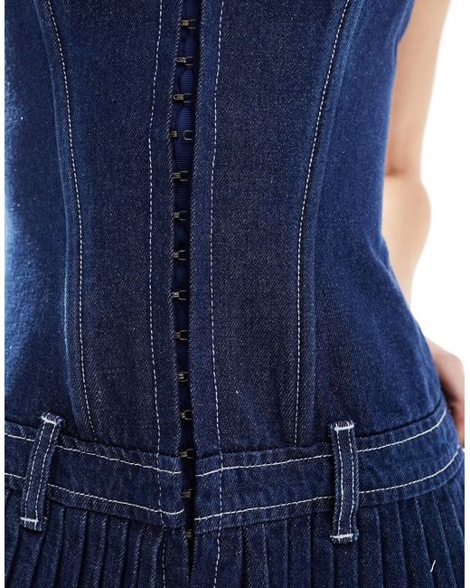Vestito corto di jeans a pieghe lavaggio indaco con chiusura con gancetti di Lioness in Blue
