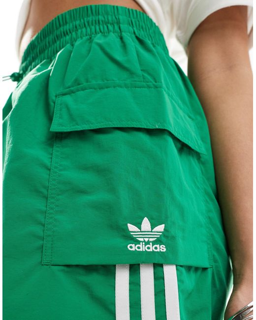 Pantaloncini cargo verdi con tre strisce di Adidas Originals in Green