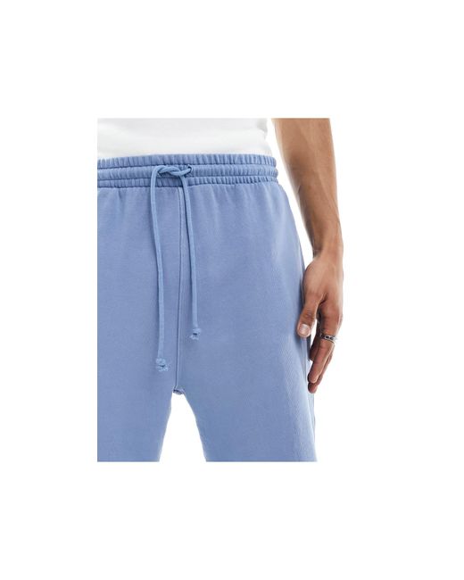 Pantaloncini oversize unisex denim slavato con orlo grezzo di ASOS in Blue
