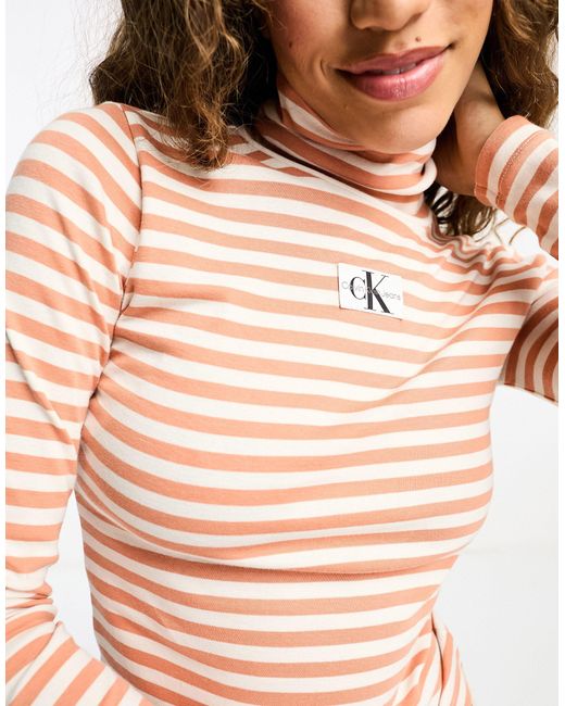 Top con collo alto a righe bianche e arancioni di Calvin Klein in White