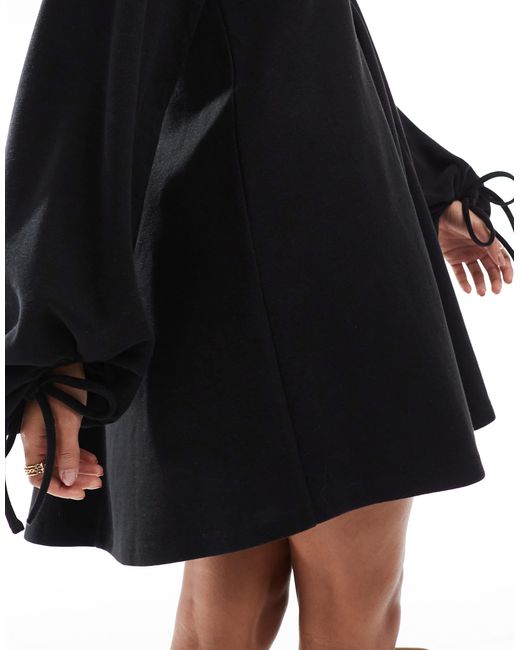Robe courte ultra douce à col v avec ourlet évasé et manches nouées ASOS en coloris Black