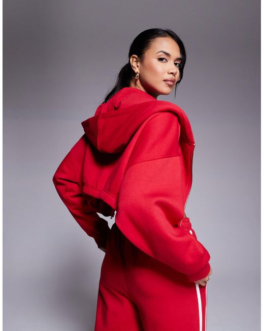 Studio - sweat à capuche court d'ensemble en coton mélangé à fermeture éclair et inscription running club Kaiia en coloris Red