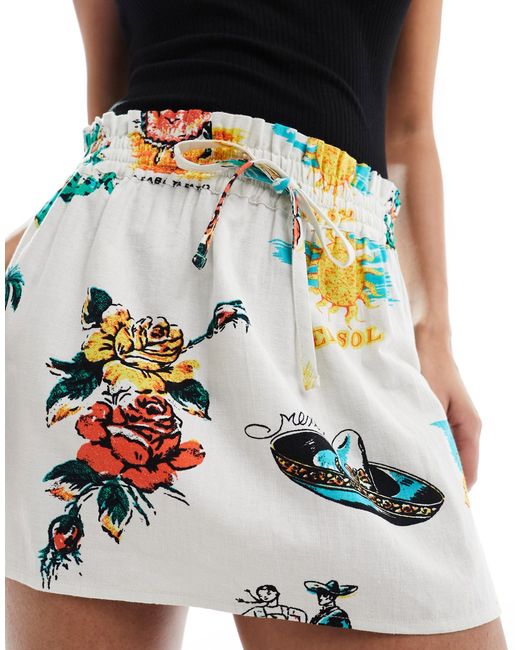 Mini-jupe nouée à la taille en aspect lin imprimé tropical ASOS en coloris Black