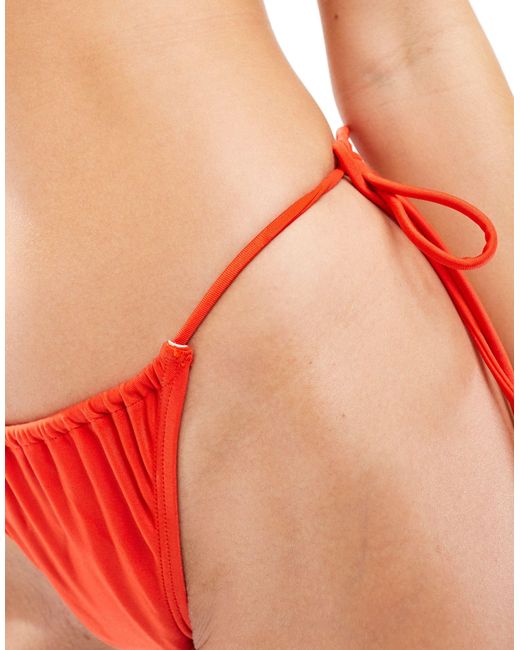 Slip bikini con davanti a v e dettaglio ad anello di Bershka in Red