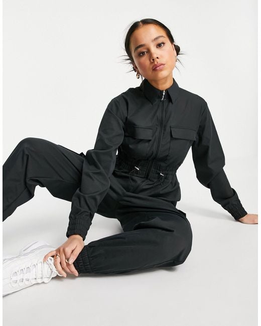 nsw swoosh utility jumpsuit in black