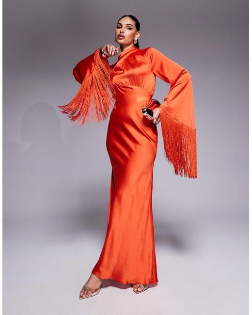 Robe longue coupée en biais en satin avec col drapé et manches frangées ASOS en coloris Orange