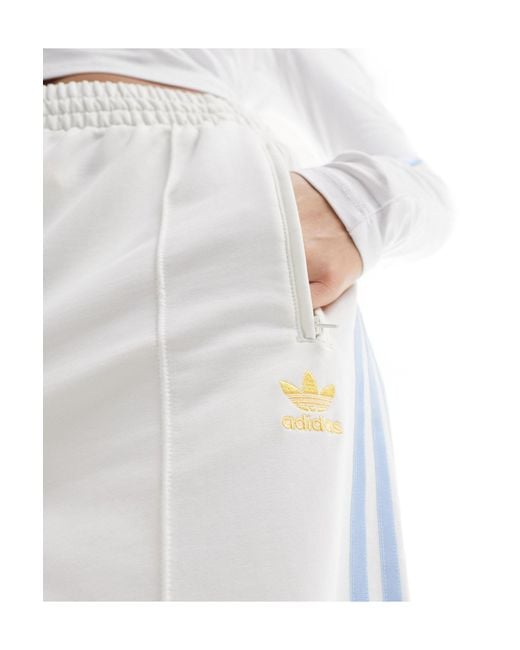 Pantaloni della tuta sporco e blu con tre righe di Adidas Originals in White