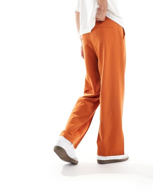 Pantaloni eleganti a fondo ampio con pinces e spacchi laterali ruggine di ASOS in Orange da Uomo