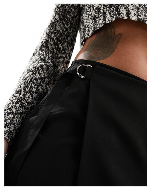 Mini-jupe portefeuille à poches cargo et boucle sur le côté Pieces en coloris Black