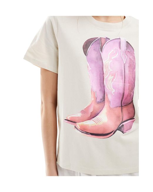 T-shirt a maniche corte beige chiaro con stampa di stivali da cowboy sul davanti di Monki in Pink