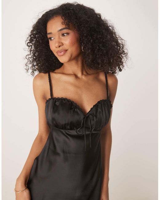 Robe mi-longue satinée froncée devant Gina Tricot en coloris Black