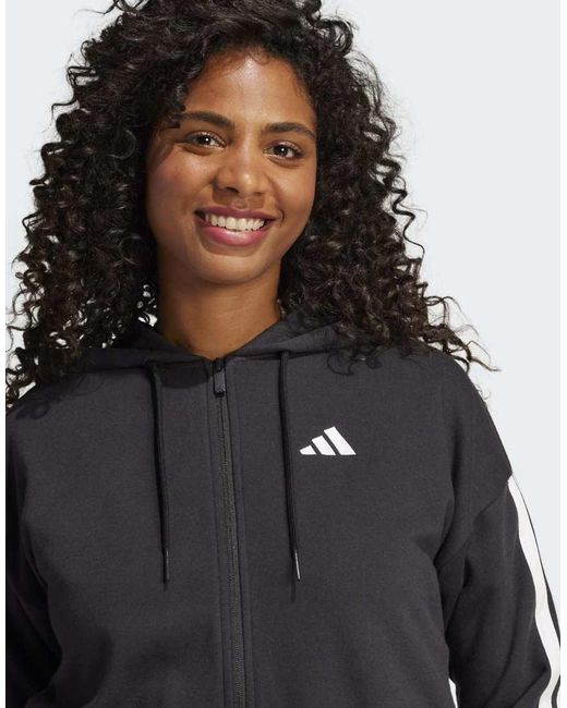 Sudadera Negra Y Blanca Con Capucha, Cremallera Y 3 Rayas De Felpa Rizada Essentials De -Negro Adidas Originals de color Black