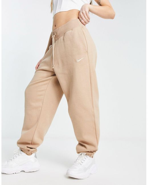 Nike Mini Swoosh Oversized High Rise joggers in Natural Lyst