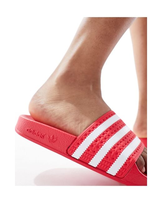 Adilette - sliders rosso corallo di Adidas Originals in Red