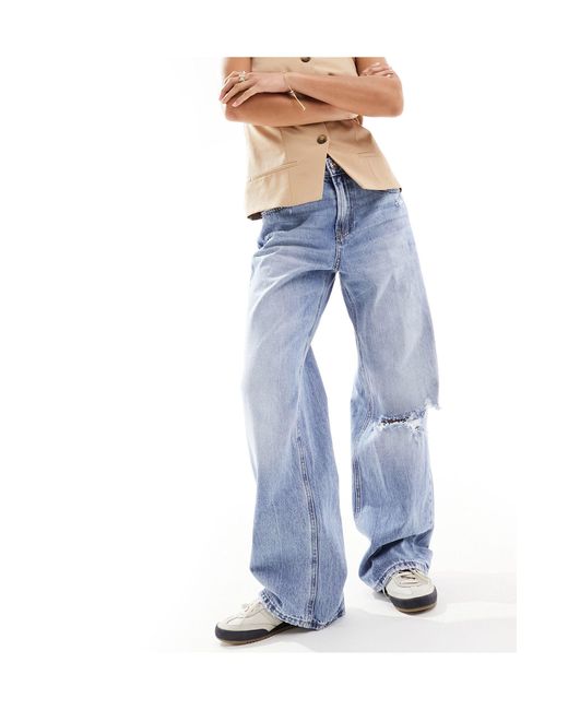 Petite - dad jeans a fondo ampio medio con strappi di Stradivarius in Blue