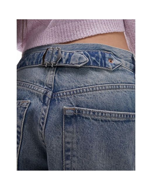Jeans con cinturino sul retro lavaggio candeggiato sporco di TOPSHOP in Blue