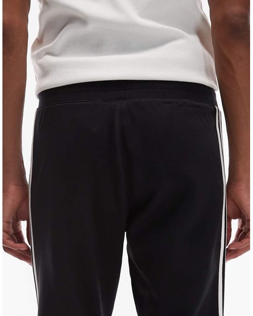 Adidas Originals Blue Three Stripe joggers for men