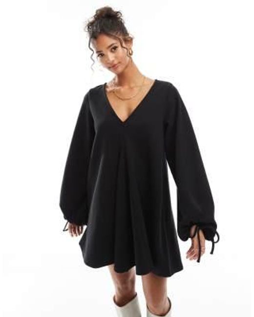 Robe courte ultra douce à col v avec ourlet évasé et manches nouées ASOS en coloris Black