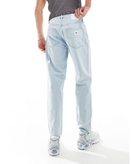 Armani Exchange – weite, schmal zulaufende jeans mit heller waschung in Blue für Herren
