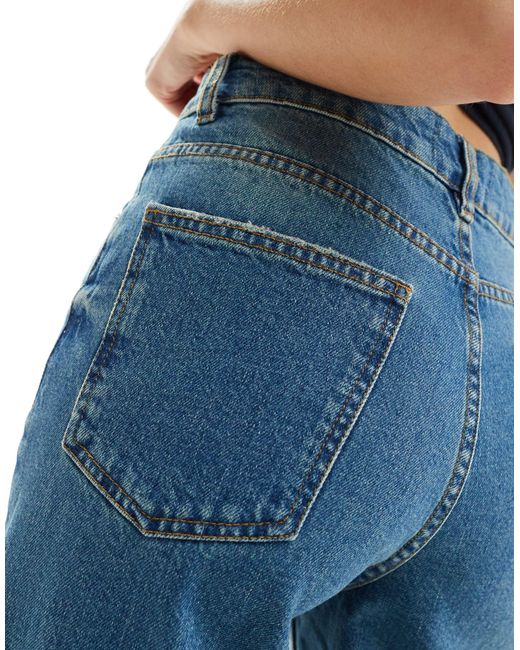 Jeans taglio corto tinto medio a fondo ampio di ASOS in Blue